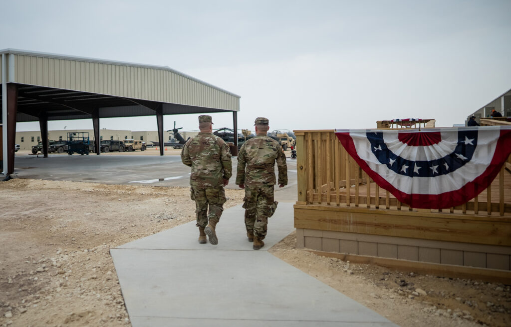 2 Military Personnel Walking at a Forward Operating Base